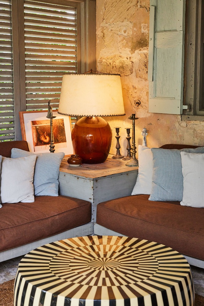 Indoor living room scene with a round coffee table, two sofas with pillows, and a table lamp, creating a cozy and inviting atmosphere.