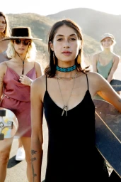 Group of four young women holding skateboards outdoors in a sunny mountain landscape by photographer Cheyenne Ellis.
