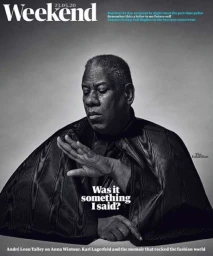 Andre Leon Talley wearing a black cape with hand raised in a portrait by photographer Squire Fox