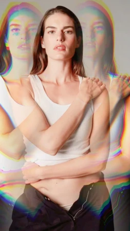 Portrait of a woman wearing a white tank top and dark trousers with chromatic aberration multiple exposure effects