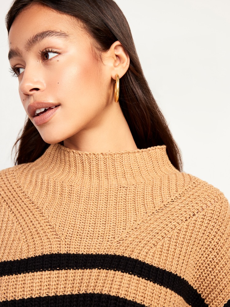 Portrait of a young woman wearing a striped knit sweater with gold hoop earrings, showcasing a close-up of her face and upper body.