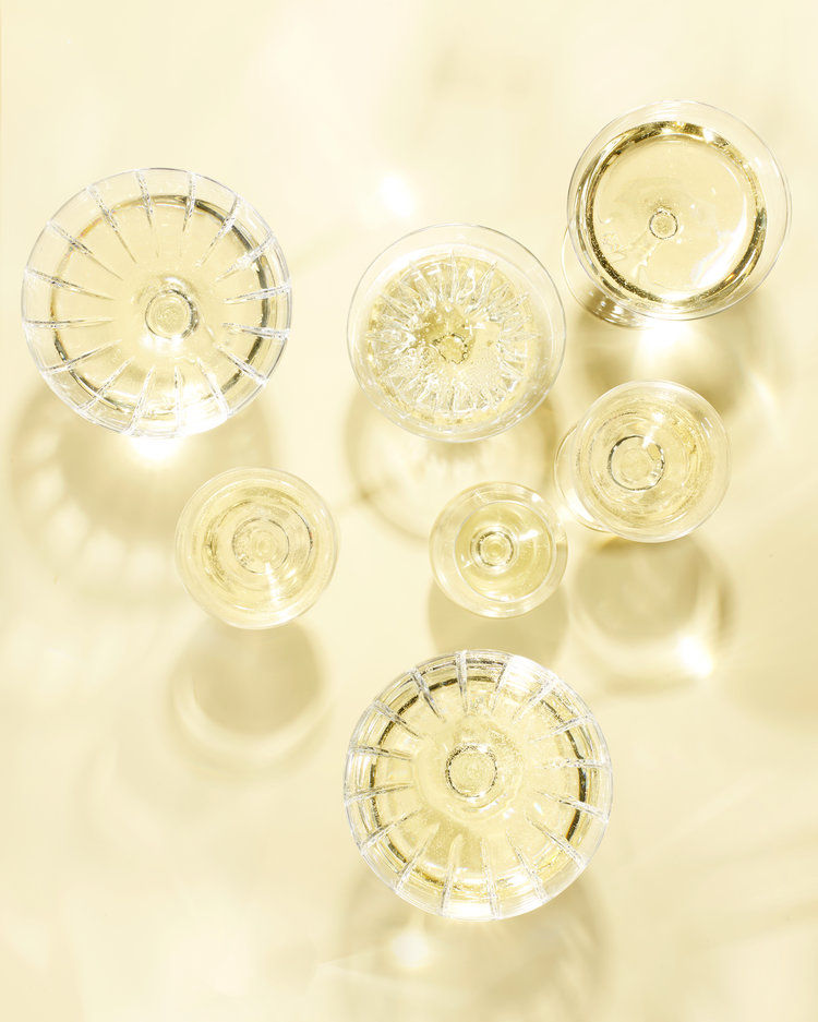 Overhead shot of champagne flutes filled with sparkling wine on a gold background, perfect for celebrations and festive occasions.