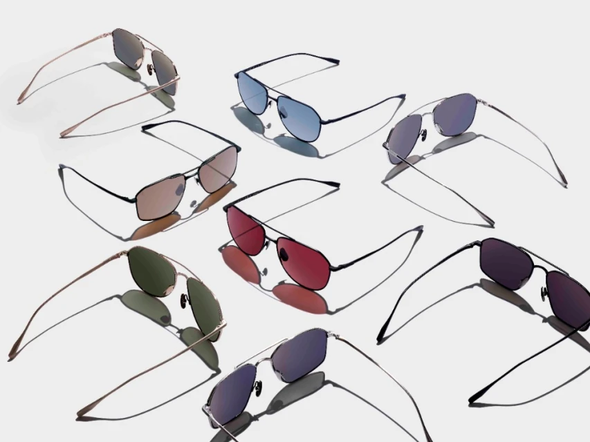 Overhead product shot of sunglasses with different colored lenses and dark metal frames arranged on a white surface with their shadows.