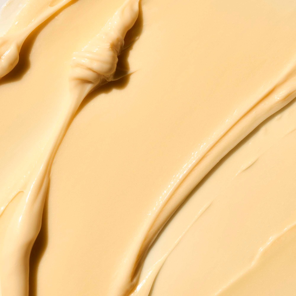 Close-up view of thick, textured beige cream or lotion with swirls and smooth areas, suitable for beauty or skincare product marketing.