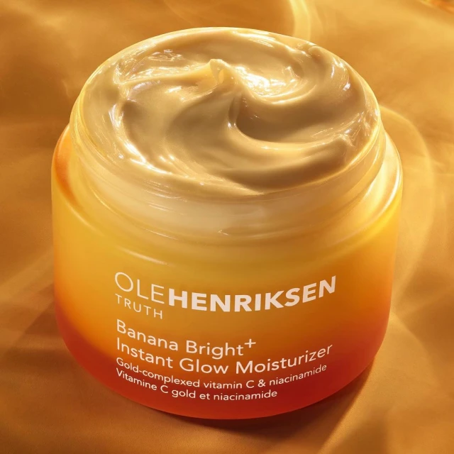 Ole Henriksen Banana Bright+ Instant Glow Moisturizer in a jar, showcasing its creamy texture and vibrant yellow and orange packaging.
