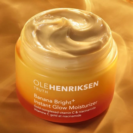 Ole Henriksen Banana Bright+ Instant Glow Moisturizer in a jar, showcasing its creamy texture and vibrant yellow and orange packaging.