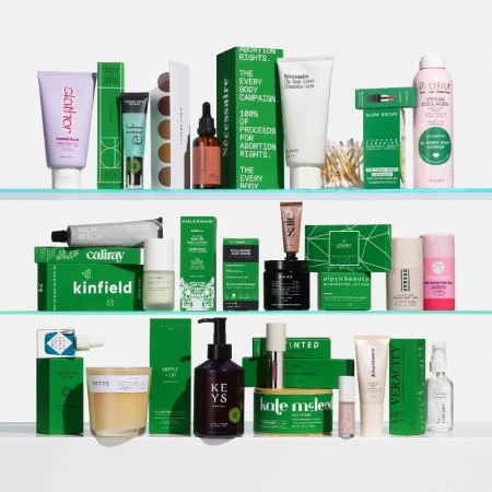 Collection of skincare and cosmetic products on clear shelves, including creams, serums, and cleansing products in green and neutral packaging.