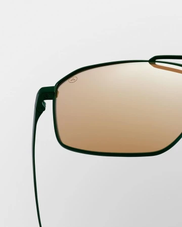 Close-up of sleek, green-framed sunglasses with amber lenses against a clean, bright background, highlighting eyewear fashion.