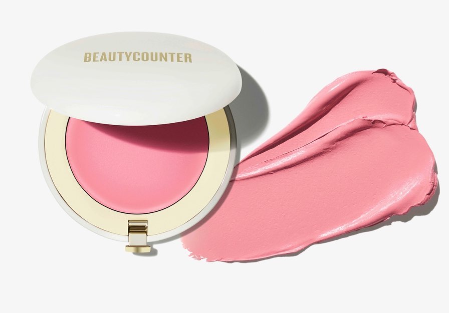 Beautycounter cream blush compact with blush swatch on a white background. Cosmetic product shot for beauty and makeup.