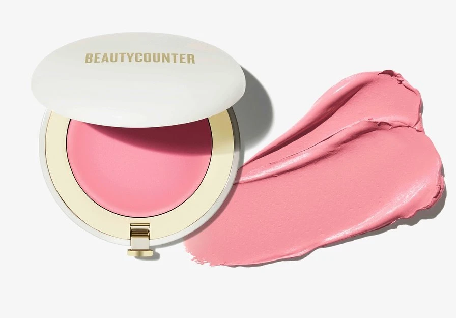 Beautycounter cream blush compact with blush swatch on a white background. Cosmetic product shot for beauty and makeup.
