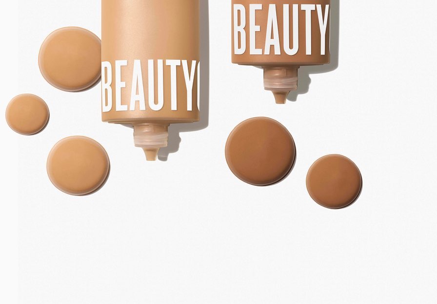 Close-up shot of two beige-colored beauty product containers, with 'BEAUTY' printed on them, surrounded by circular product samples on white.