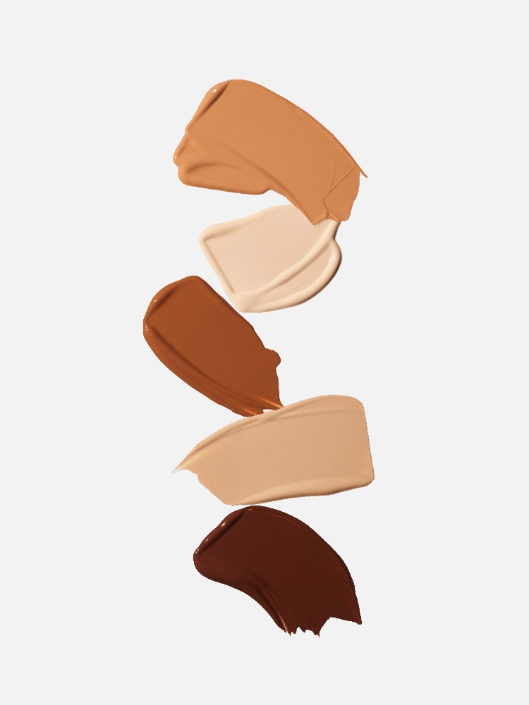 Swatches of different shades of makeup foundation lined up vertically on a white background, showcasing the color range.