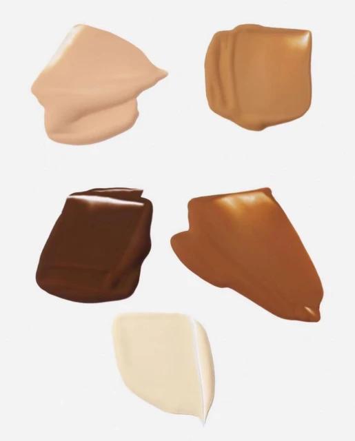 Close-up of various shades of liquid foundation swatches in fair, medium and dark tones on a white background, beauty concept.