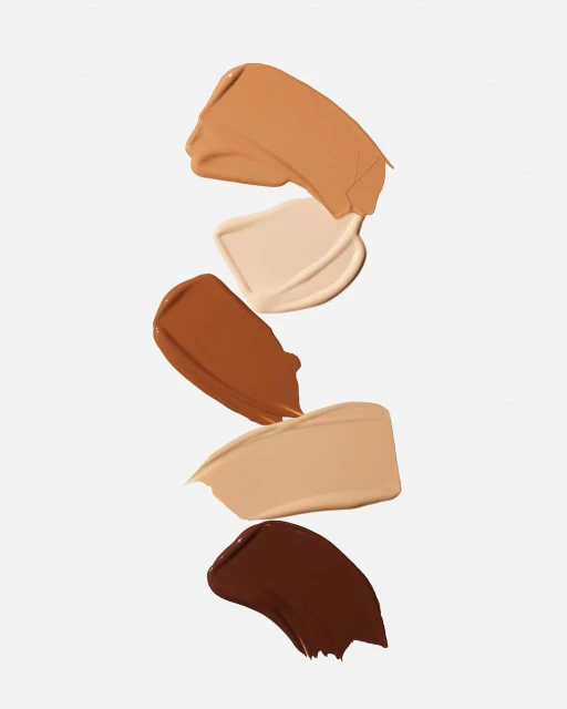 Cosmetic foundation swatches in various shades of beige, tan, and brown isolated against a clean white background.