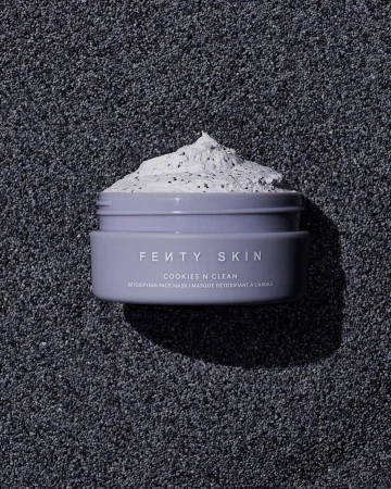Close-up of Fenty Skin Cookies N Clean detoxifying face mask in a lavender jar on a textured dark grey background.