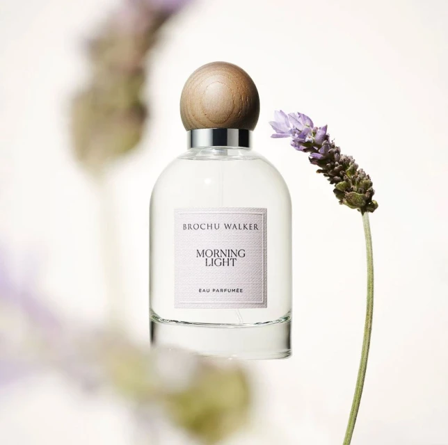 Brochu Walker Morning Light perfume bottle on a white backdrop with a lavender sprig accent, creating a beauty or fragrance product shot.