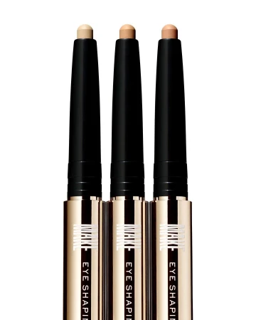 Three eye shaping sticks in a row, featuring black and gold packaging with cream-colored product, against a white background.