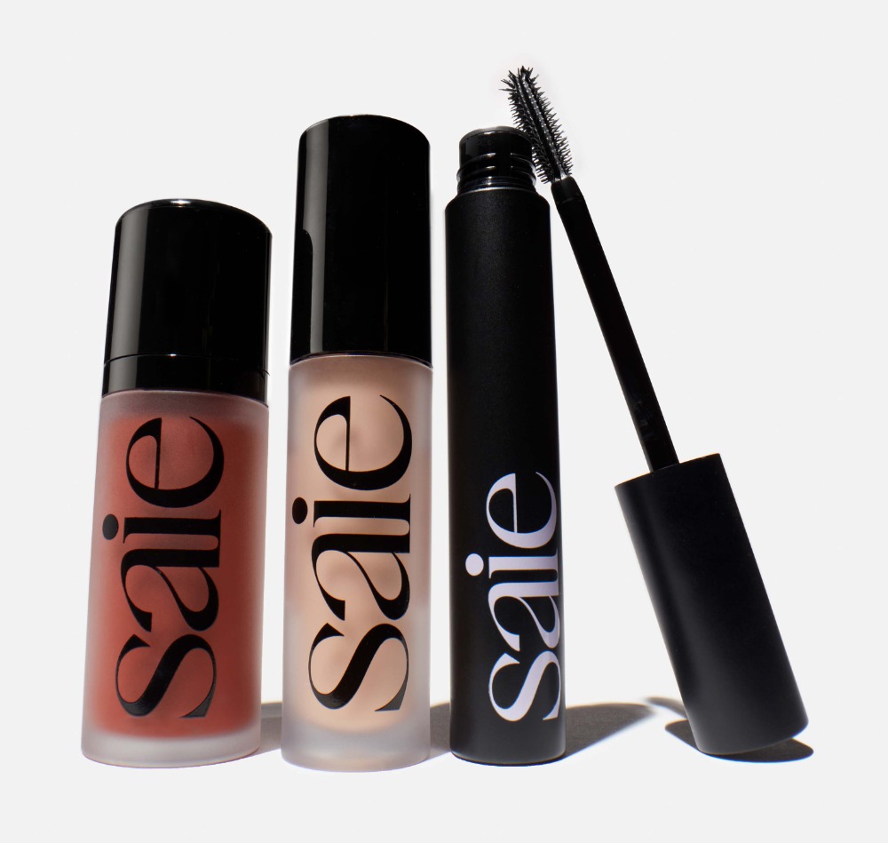 Three 'Saie' brand cosmetic products: a blush, a concealer, and a mascara, set against a bright white backdrop in a product shot.