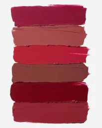 Six horizontal lipstick swatches in stacked rows showing shades of magenta, nude, bright red, brown, and deep crimson on a white background