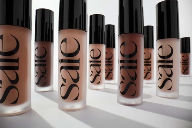Group of frosted glass cosmetic bottles with black caps arranged on a clean white surface