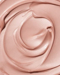 Close-up macro shot of smooth, glossy pink cosmetic cream swirled into a soft, textured pattern.