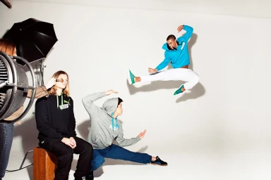 Behind the scenes photo of a model mid-air kicking in a studio setting photographed by Jon Johnson.