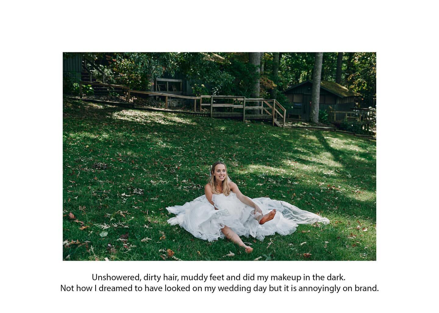 A woman in a wedding dress sits barefoot in a grassy field near a forest, giving a carefree, slightly humorous vibe in natural light.