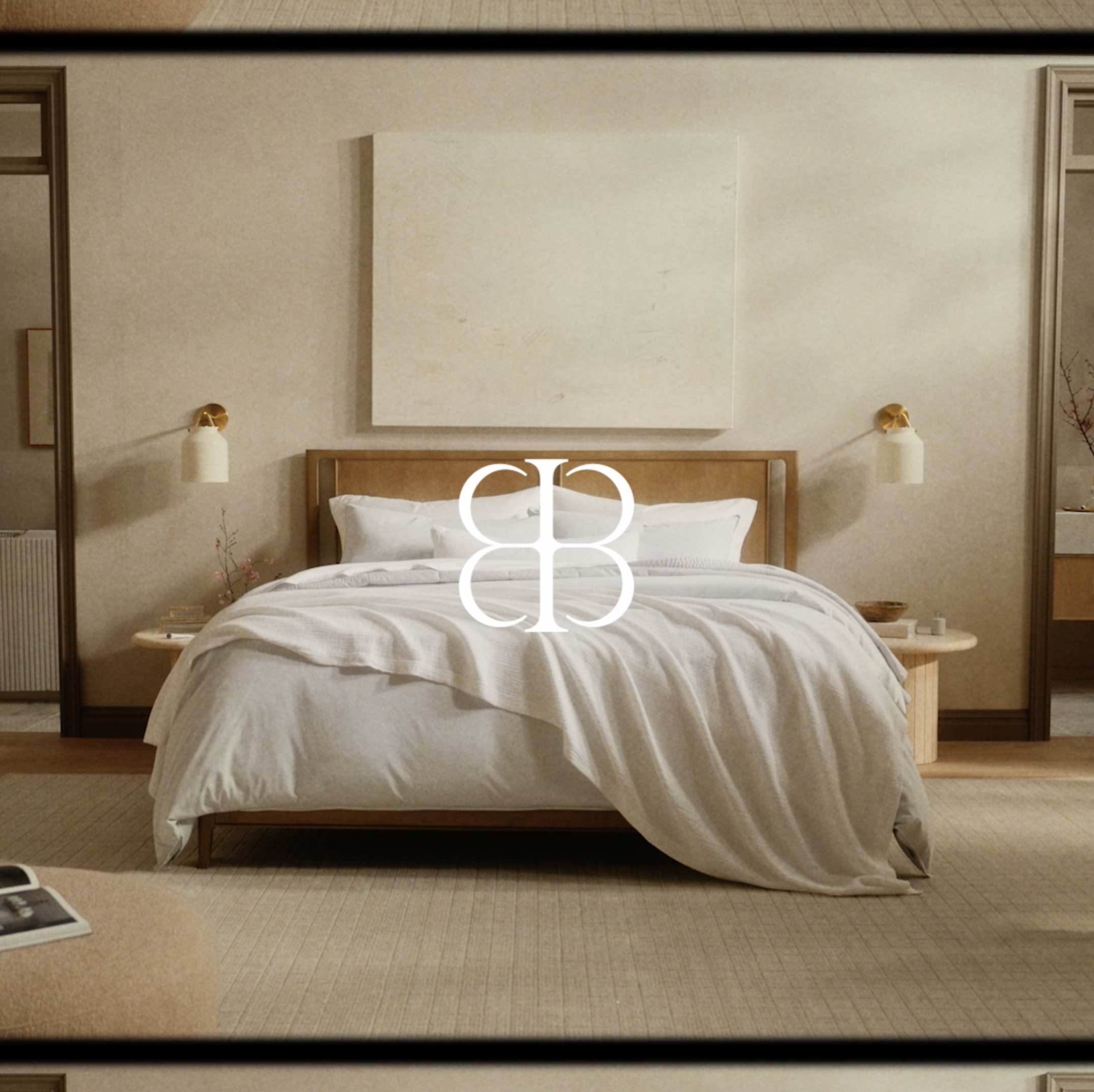 Interior of a bedroom with a king-size bed, wooden headboard, a large square painting, and two small round side tables.