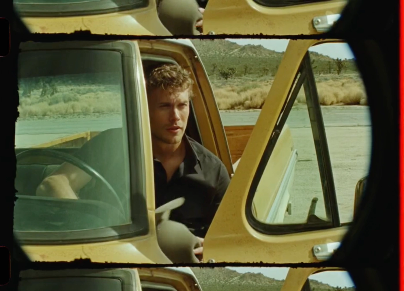 Man sitting inside a yellow pickup truck framed by motion picture film sprocket holes and visible frame lines