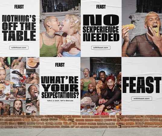 Eye-level shot of six posters glued to a brick wall, each featuring people eating and taglines for FEAST, with the website withfeast.com.