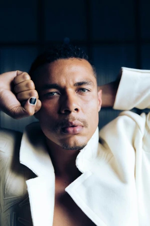 Portrait of a man wearing a white collared jacket with black nail polish, photographed by Camraface