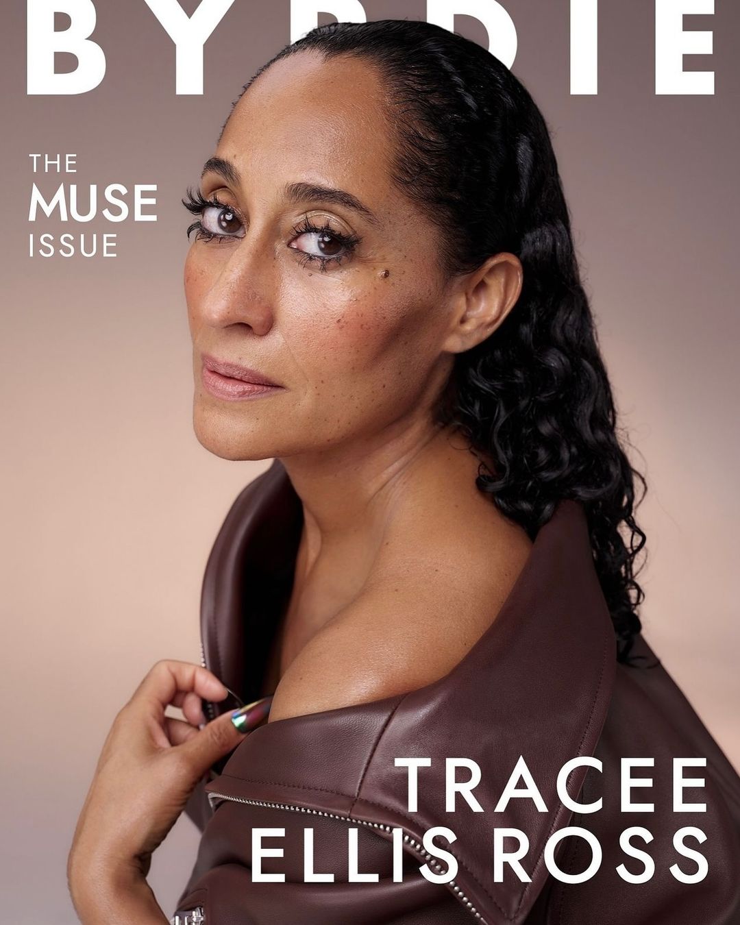 Tracee Ellis Ross on the cover of Byrdie's 'The Muse' issue, wearing a brown leather jacket, captured in a studio with soft lighting.
