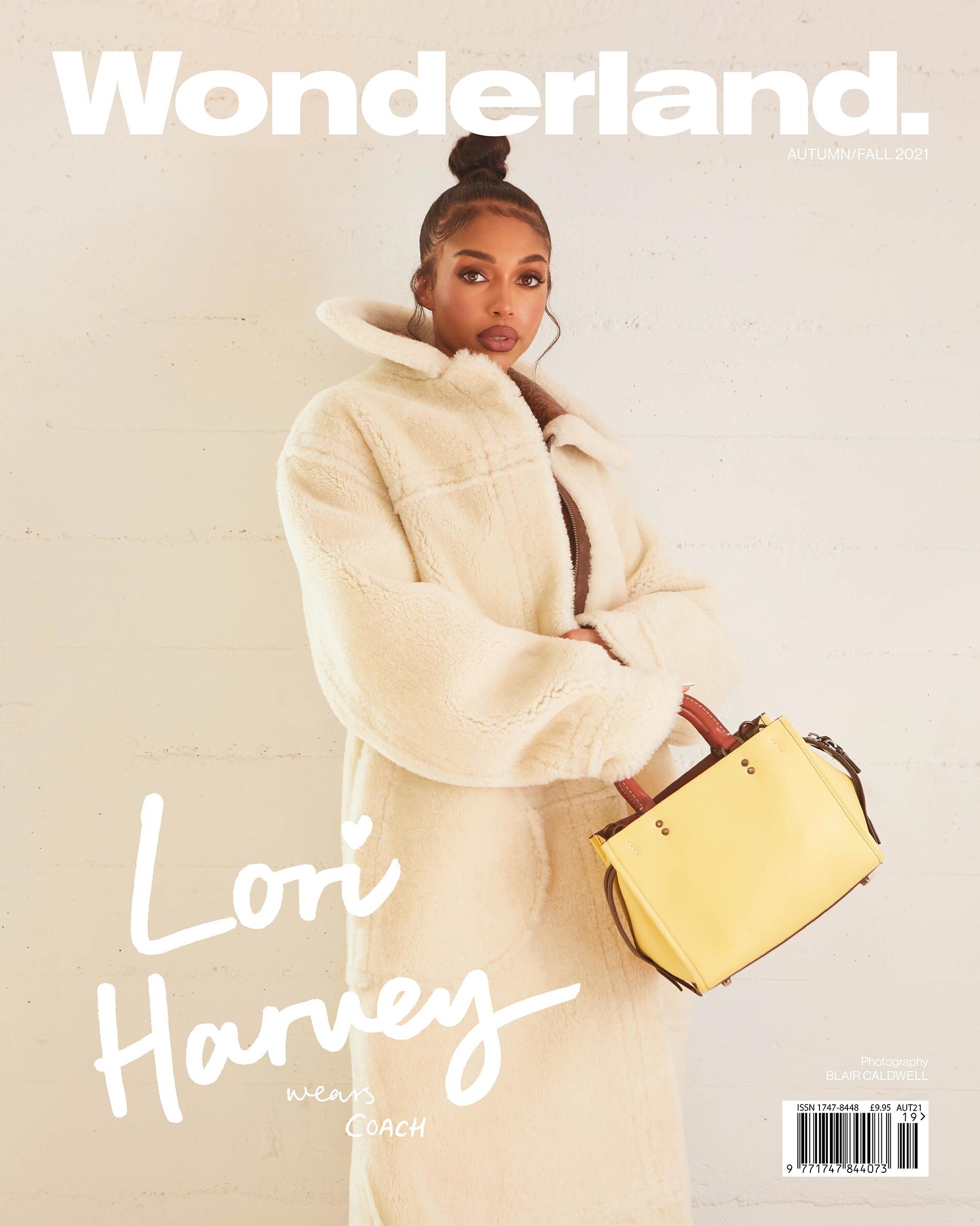 Wonderland cover featuring Lori Harvey wearing a cream coat and holding a yellow purse against a muted beige backdrop. 