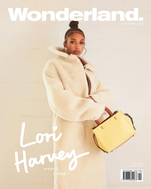Wonderland cover featuring Lori Harvey wearing a cream coat and holding a yellow purse against a muted beige backdrop. 