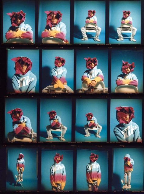 A collection of frames shows a person in a colourful hooded top and a burgundy flower-like hood posing against a blue backdrop.