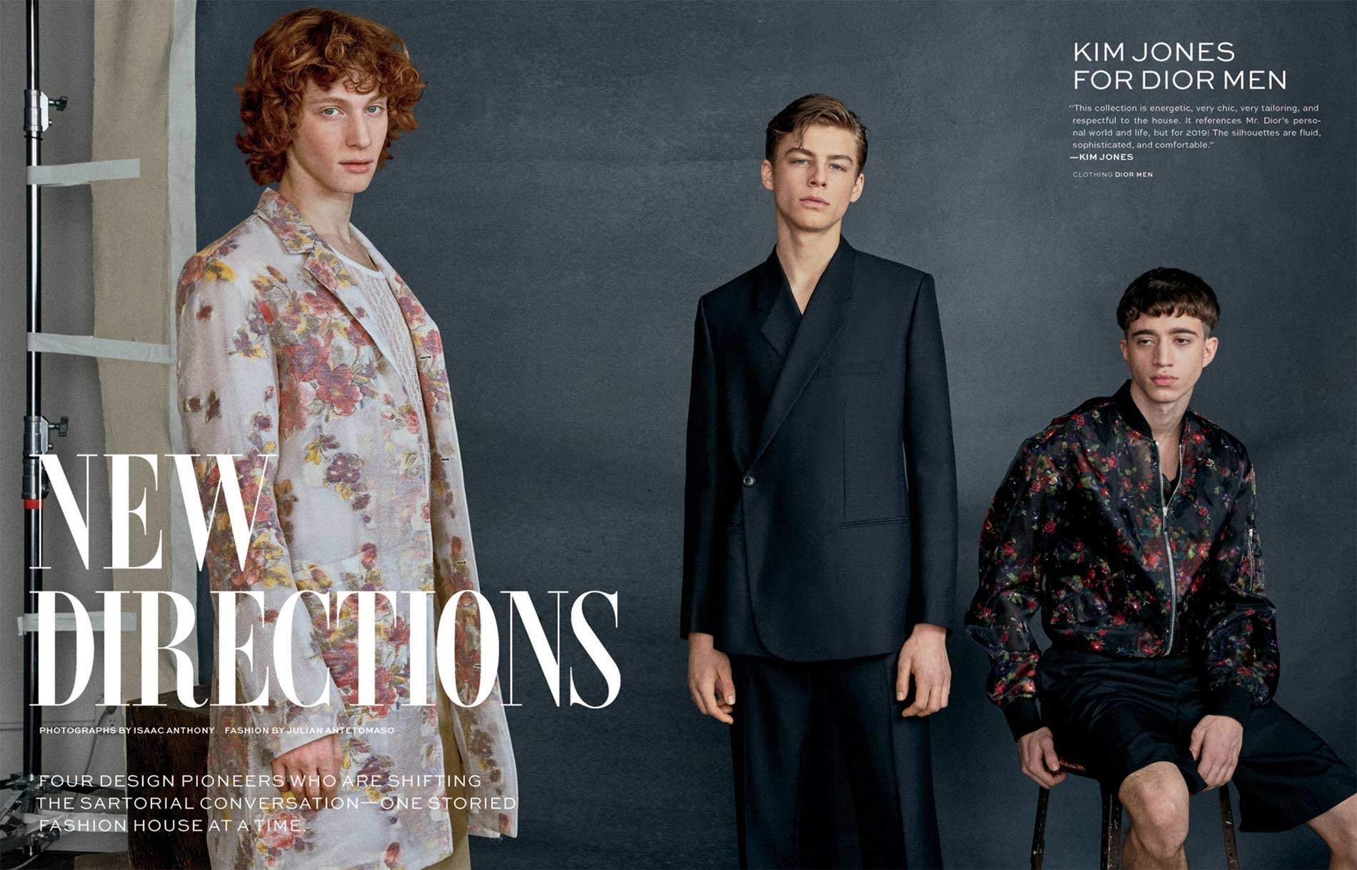 Fashion editorial shot of three young adult male models posing indoors against a grey backdrop, showcasing floral blazers and suits.