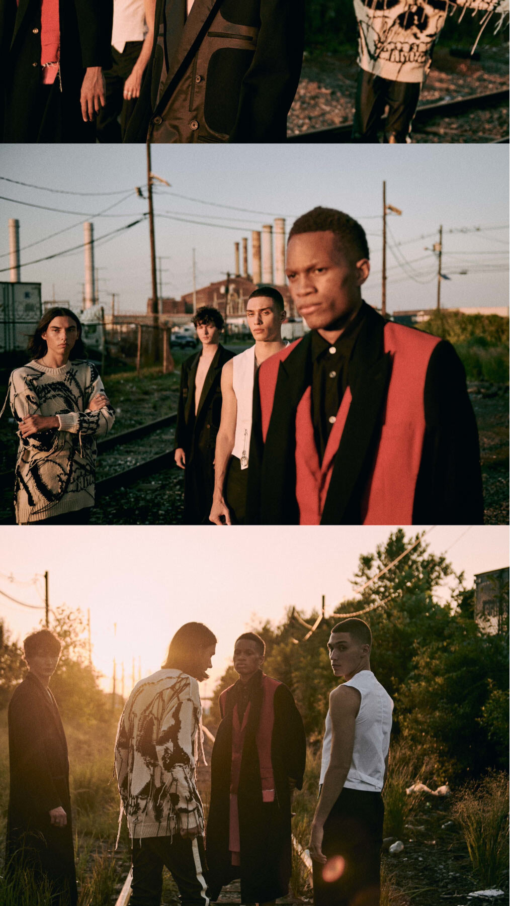 A group of stylish young men in contemporary fashion stand on railroad tracks in an industrial area at sunset in a dramatic fashion editorial.