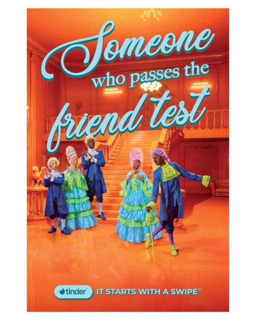 Tinder advert featuring 5 people in period costume, gathered in an orange interior. Text reads: Someone who passes the friend test.