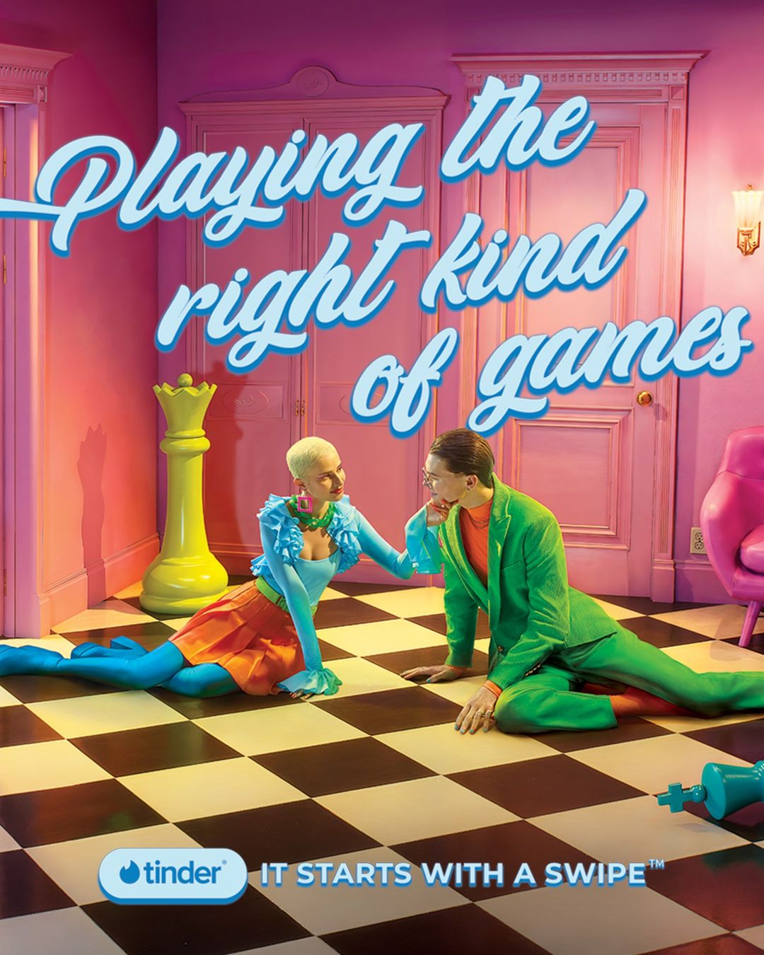Whimsical dating app ad features a stylish couple on a checkered floor, chess pieces, and pastel furniture, all under bright studio lighting.
