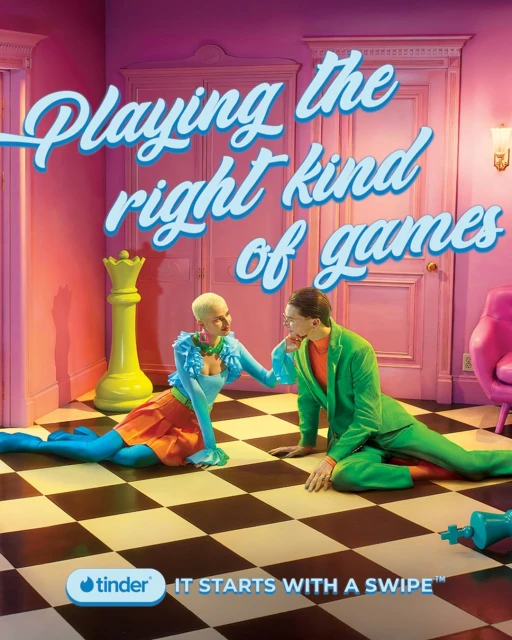 Whimsical dating app ad features a stylish couple on a checkered floor, chess pieces, and pastel furniture, all under bright studio lighting.