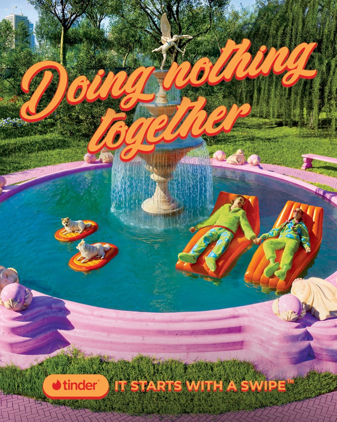 Couple floats in a pink fountain with dogs on rafts, advertising 'Doing nothing together' for Tinder with a green lawn background.