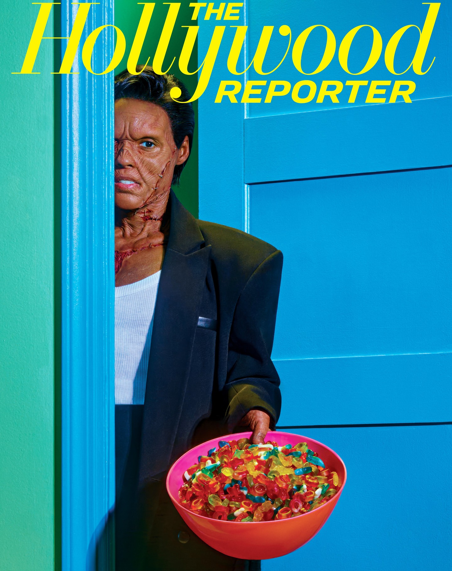 Magazine cover featuring a man with theatrical makeup holding a bowl of gummy candies in front of a turquoise door.