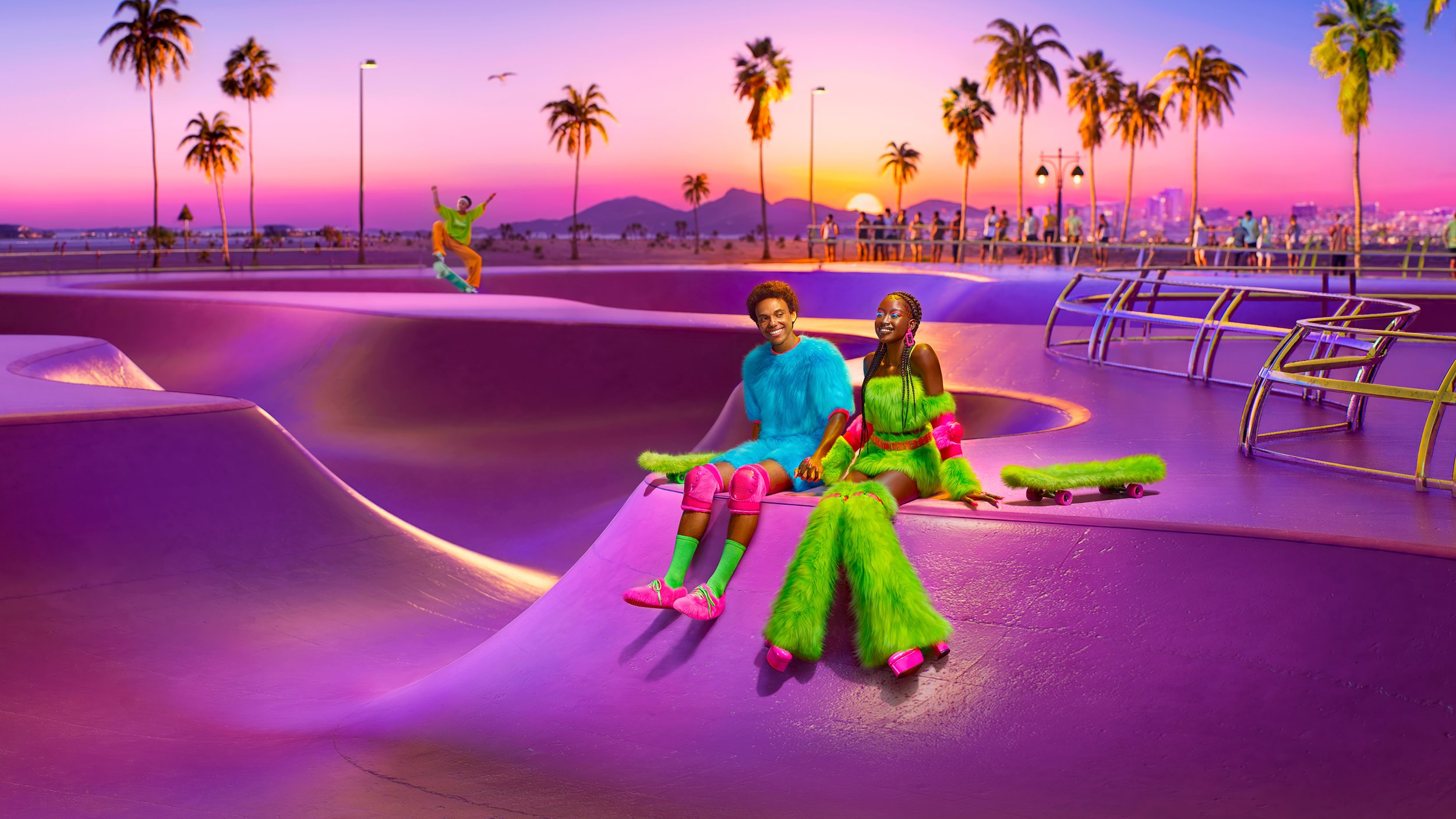 Two people sit at a purple skatepark in vibrant outfits, with a skater in the background and palm trees against a pink sunset.