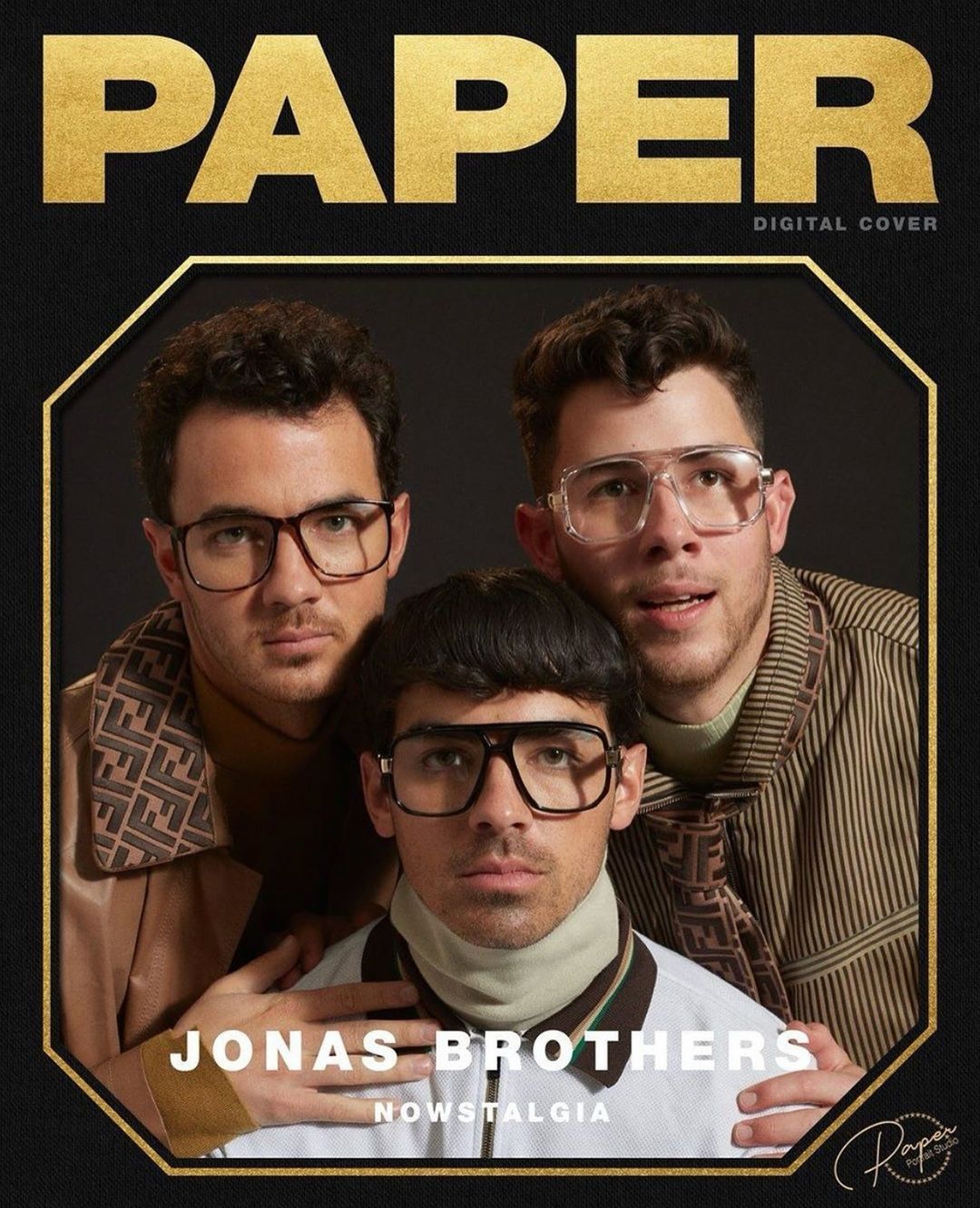Paper magazine cover featuring the Jonas Brothers in a portrait, shot with warm, gold tones and retro styling against a dark background.