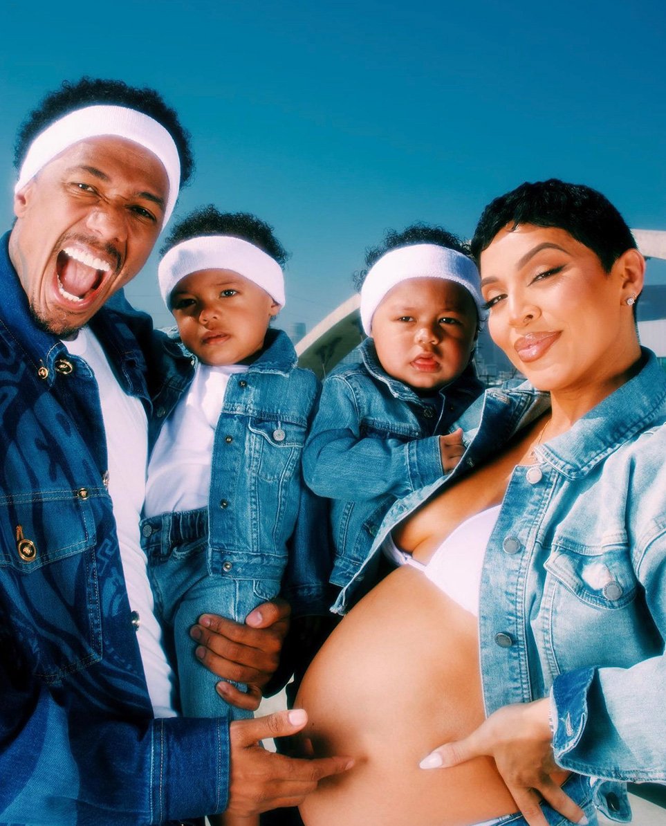 A family portrait featuring a man, woman, and two young children wearing matching denim jackets and white headbands, posing outdoors.