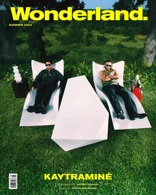 Magazine cover featuring Kaytraminé, with two men lounging on white chairs in a grassy outdoor setting, trees, and 'Wonderland' text.
