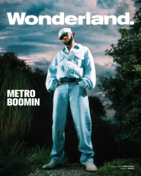 Metro Boomin wearing a light wash denim jacket and jeans with a bandana under a dramatic cloudy sky by Xavier Luggage