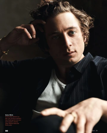 Portrait of actor Jeremy Allen White with curly brown hair wearing a white tank top and dark striped shirt, photographed by Victoria Stevens