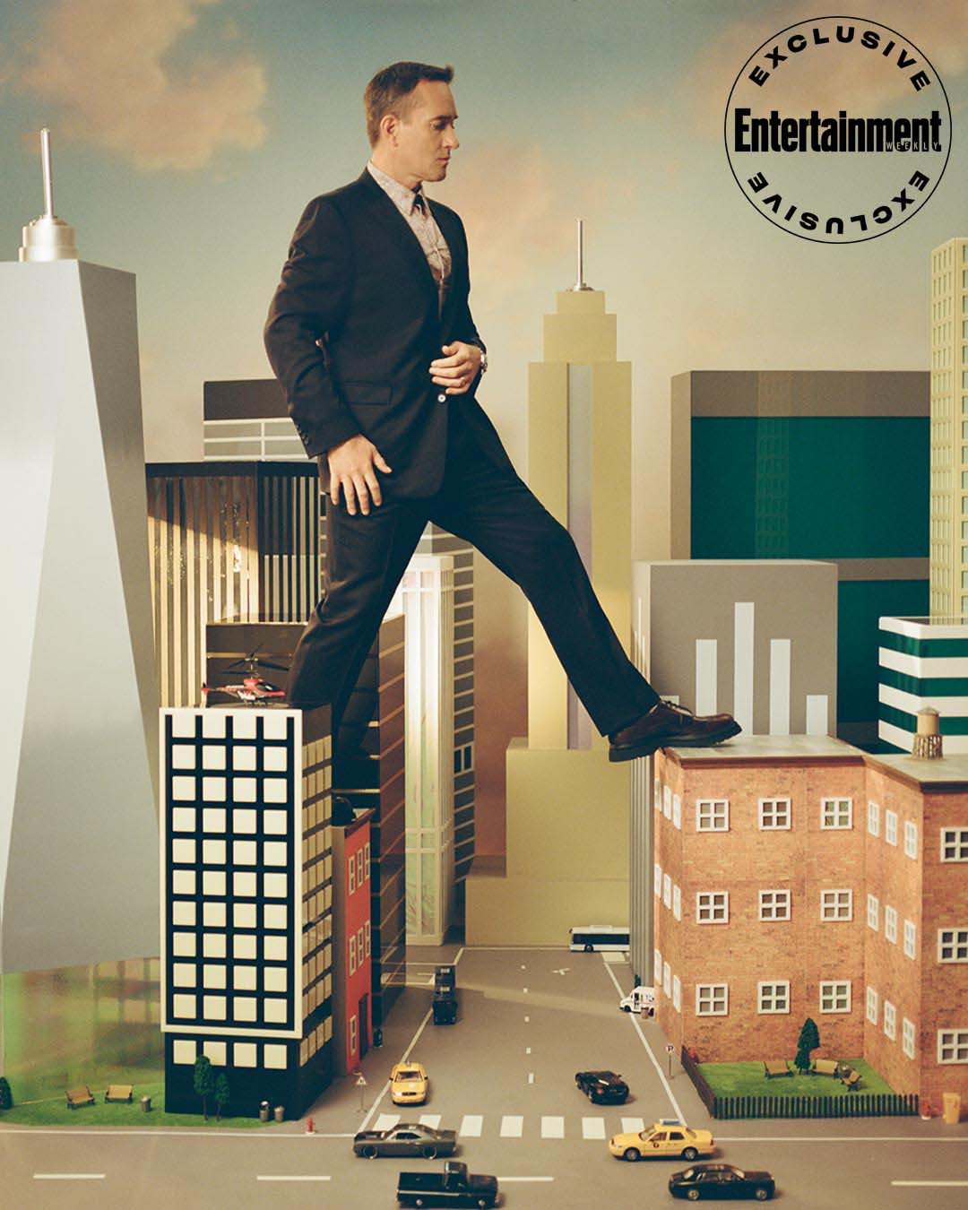 A man in a suit is walking on top of buildings in a city. Concept of a giant man among miniature buildings with cloudy skies.