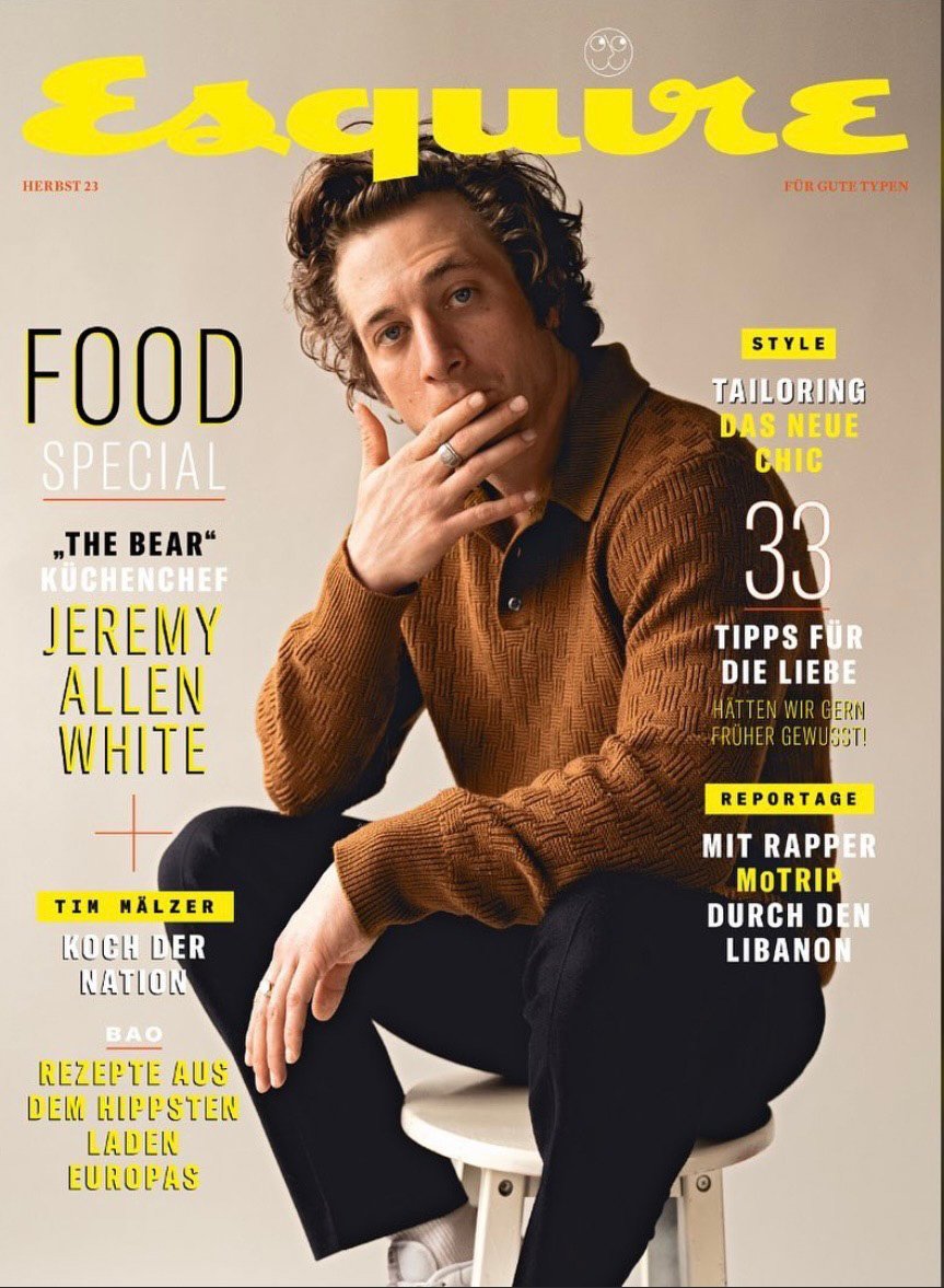 Esquire magazine cover featuring actor Jeremy Allen White in a brown textured sweater, seated on a white stool against a neutral background.